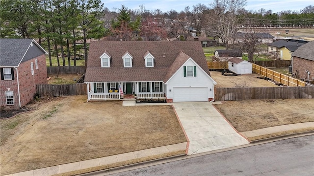 cape cod-style house with a porch, fence, and driveway