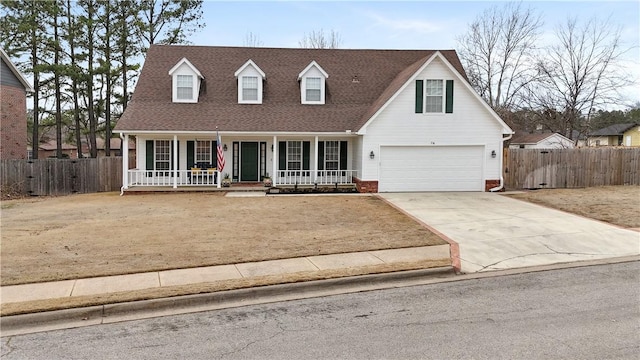 cape cod house with a porch, fence, a garage, and driveway