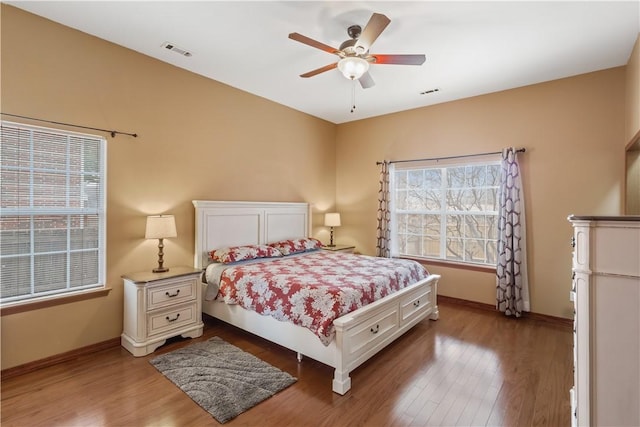 bedroom with visible vents, baseboards, and wood finished floors