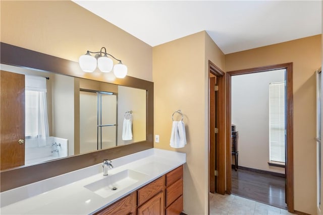 full bathroom with vanity, an enclosed shower, and tile patterned flooring