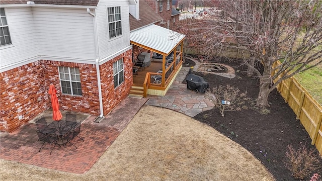 exterior space with a patio area, brick siding, and a fenced backyard