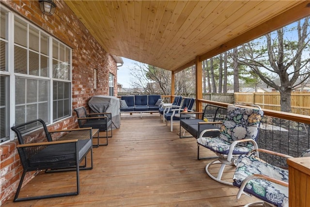 wooden deck featuring outdoor lounge area, fence, and grilling area