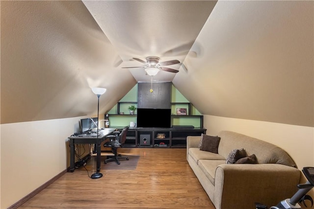 office area featuring vaulted ceiling, wood finished floors, baseboards, and ceiling fan