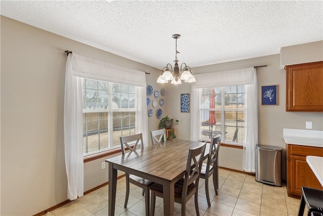 dining space featuring a notable chandelier, plenty of natural light, and a textured ceiling