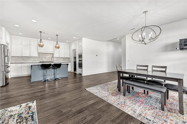 dining area featuring recessed lighting, baseboards, a chandelier, and dark wood-style flooring