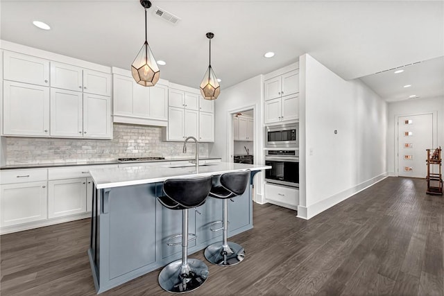 kitchen featuring a sink, stainless steel appliances, visible vents, and white cabinetry