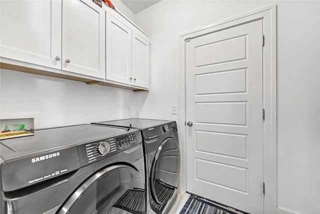 laundry area featuring washing machine and dryer and cabinet space