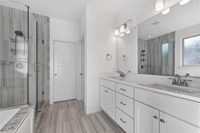 bathroom with a sink, visible vents, double vanity, and a shower stall