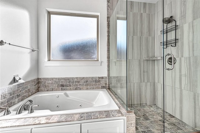 bathroom featuring a jetted tub and a shower stall