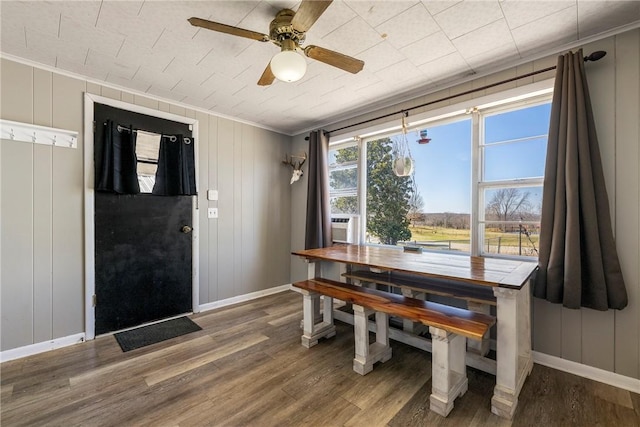 dining room featuring baseboards, crown molding, ceiling fan, and wood finished floors