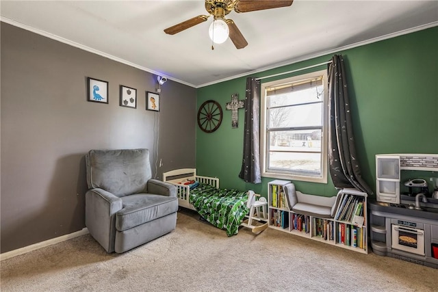 sitting room with carpet flooring, baseboards, a ceiling fan, and ornamental molding