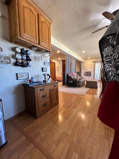 kitchen with open floor plan, light wood-type flooring, and brown cabinets