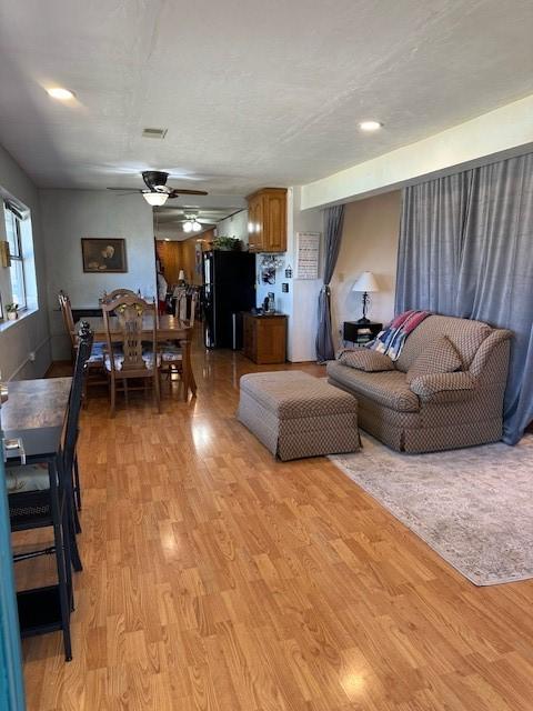 living area with light wood-style floors and ceiling fan