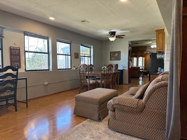 living area with visible vents, recessed lighting, a ceiling fan, and light wood-type flooring