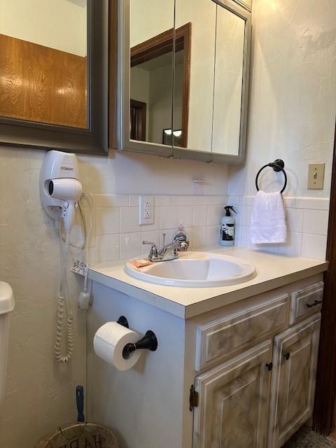 bathroom with tasteful backsplash and vanity