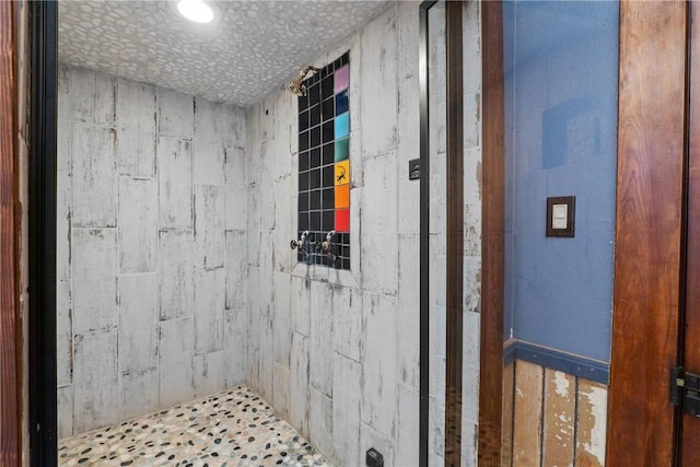 bathroom featuring a tile shower and a textured ceiling