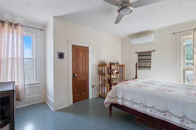 bedroom featuring hardwood / wood-style floors, crown molding, baseboards, and a wall mounted air conditioner