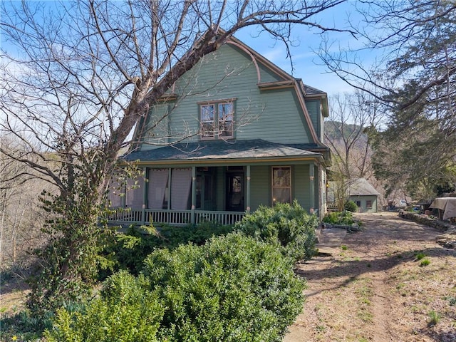 view of front facade with a gambrel roof and a porch