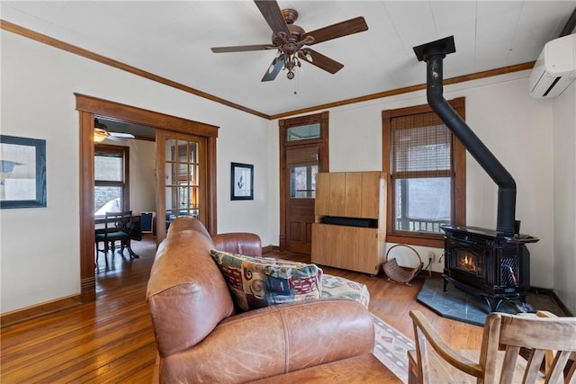 living area featuring an AC wall unit, a ceiling fan, hardwood / wood-style floors, radiator heating unit, and a wood stove