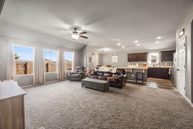 living area with recessed lighting, visible vents, dark carpet, and a ceiling fan