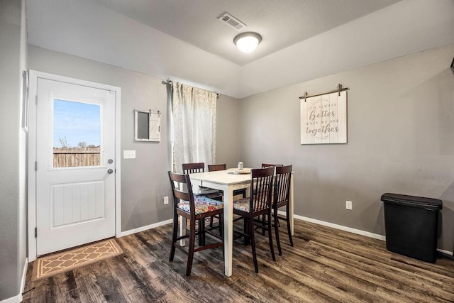 dining area featuring visible vents, baseboards, and dark wood-style flooring