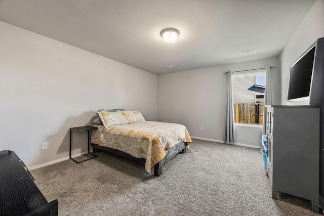 carpeted bedroom featuring visible vents, baseboards, and a textured ceiling