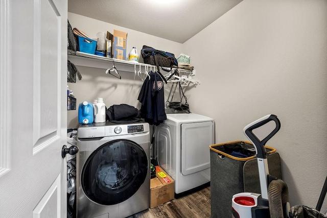 washroom featuring washer and dryer, laundry area, and wood finished floors