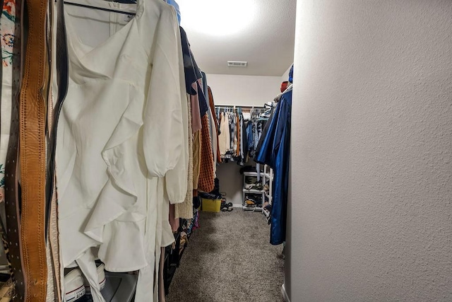 walk in closet featuring visible vents and carpet flooring