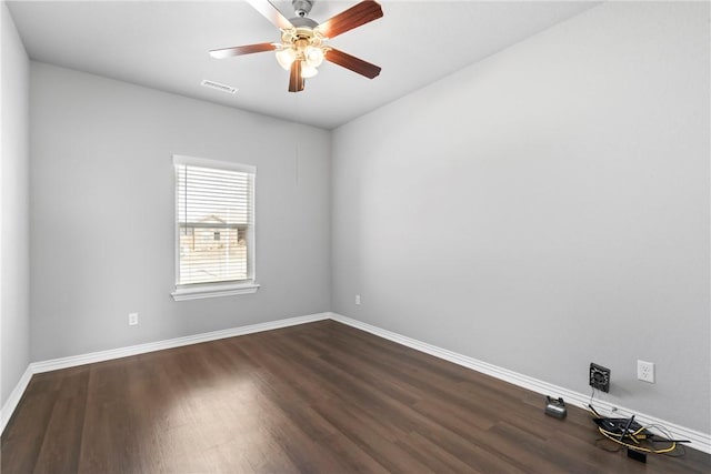 unfurnished room featuring dark wood finished floors, baseboards, visible vents, and ceiling fan