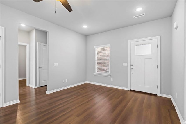 foyer with dark wood-type flooring, baseboards, visible vents, and ceiling fan