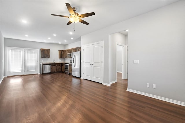 unfurnished living room with a sink, dark wood-style floors, recessed lighting, baseboards, and ceiling fan