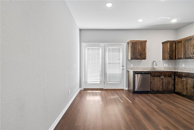 kitchen with baseboards, dark wood finished floors, a sink, dark brown cabinetry, and stainless steel dishwasher