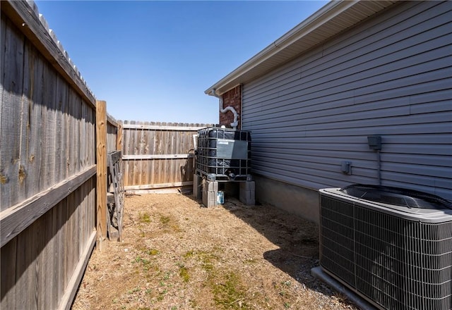 view of yard with a fenced backyard and central AC