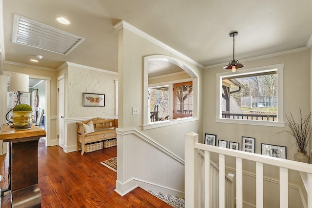 hall featuring a wainscoted wall, an upstairs landing, dark wood-style flooring, and crown molding