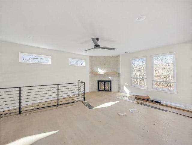 interior space featuring a large fireplace and ceiling fan