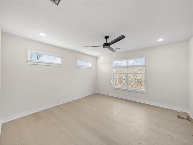 spare room with recessed lighting, light wood-style flooring, a ceiling fan, and baseboards