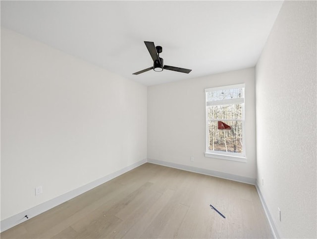 empty room featuring ceiling fan, baseboards, and light wood-style floors