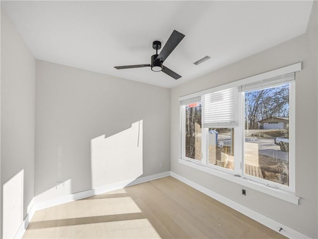 empty room with visible vents, baseboards, ceiling fan, and wood finished floors