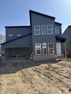 rear view of house featuring a garage and aphalt driveway