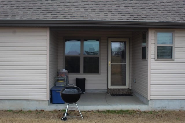 entrance to property with a shingled roof