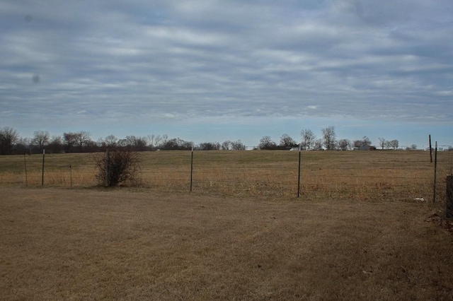 view of yard with a rural view and fence