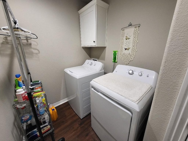 washroom featuring washer and dryer, cabinet space, and dark wood-type flooring