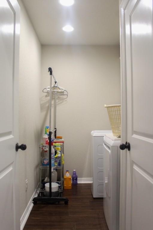 laundry area with washer and clothes dryer, laundry area, dark wood-type flooring, and baseboards