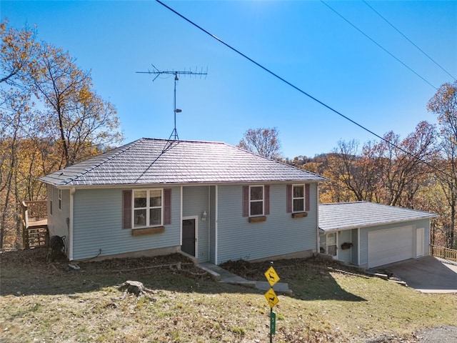 view of front of home featuring an outbuilding, a garage, driveway, and a front yard