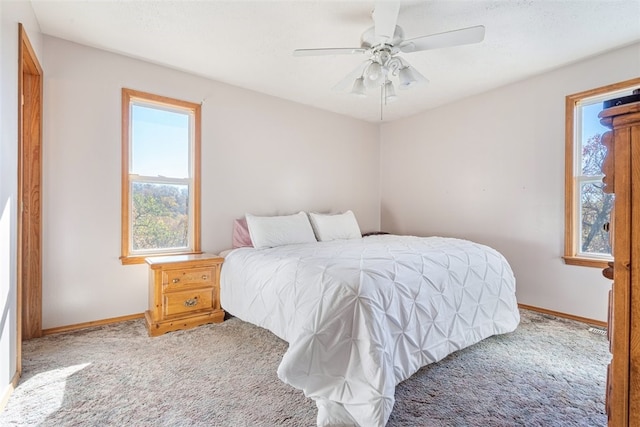 bedroom with ceiling fan, baseboards, and carpet floors