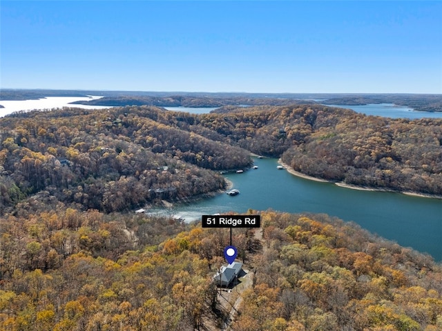 aerial view featuring a forest view and a water view