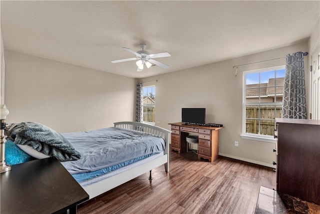 bedroom featuring a ceiling fan, wood finished floors, and baseboards