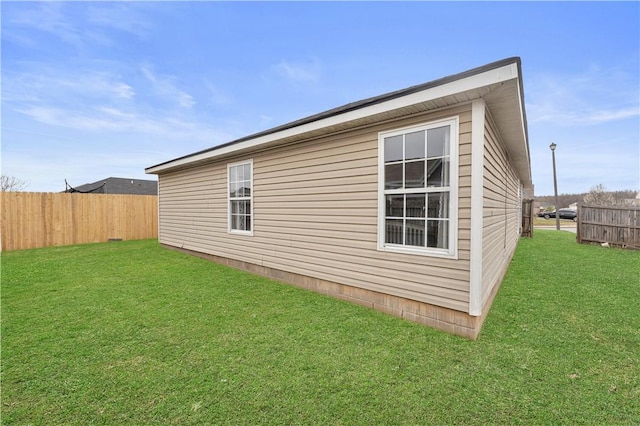 view of home's exterior featuring a lawn and fence