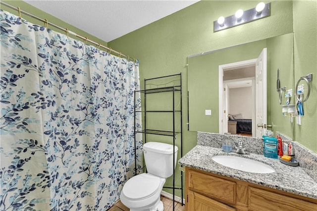 ensuite bathroom with connected bathroom, toilet, a shower with curtain, a textured wall, and vanity