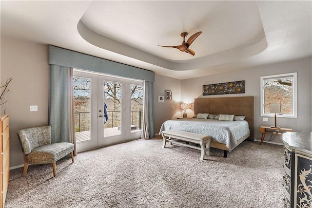 carpeted bedroom with ceiling fan, french doors, a raised ceiling, and access to exterior